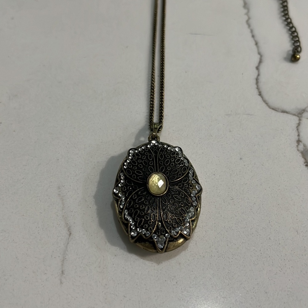 Gold tone long necklace with statement charm
